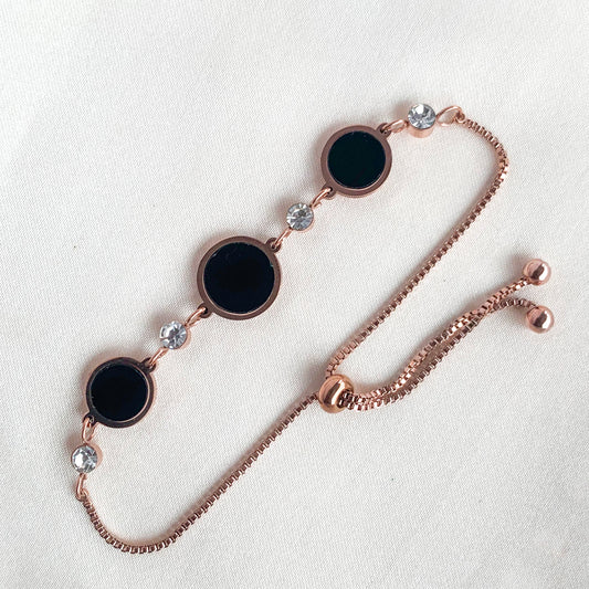 Adjustable rose gold bracelet with black circular accents and crystal highlights – chic accessory for casual or festive looks