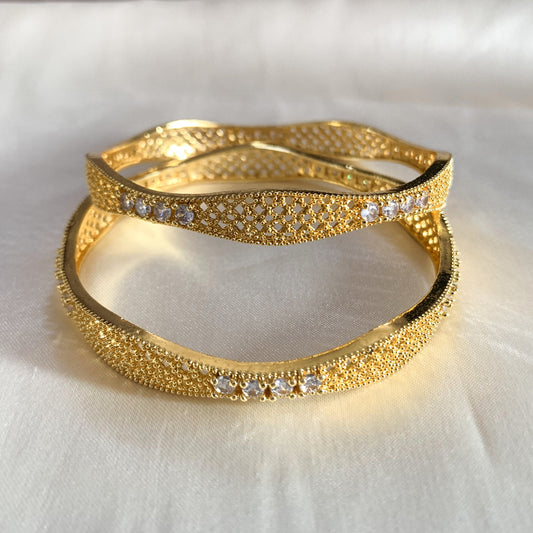 Designer gold-plated bangles adorned with shimmering white stones – perfect for festive and special occasions