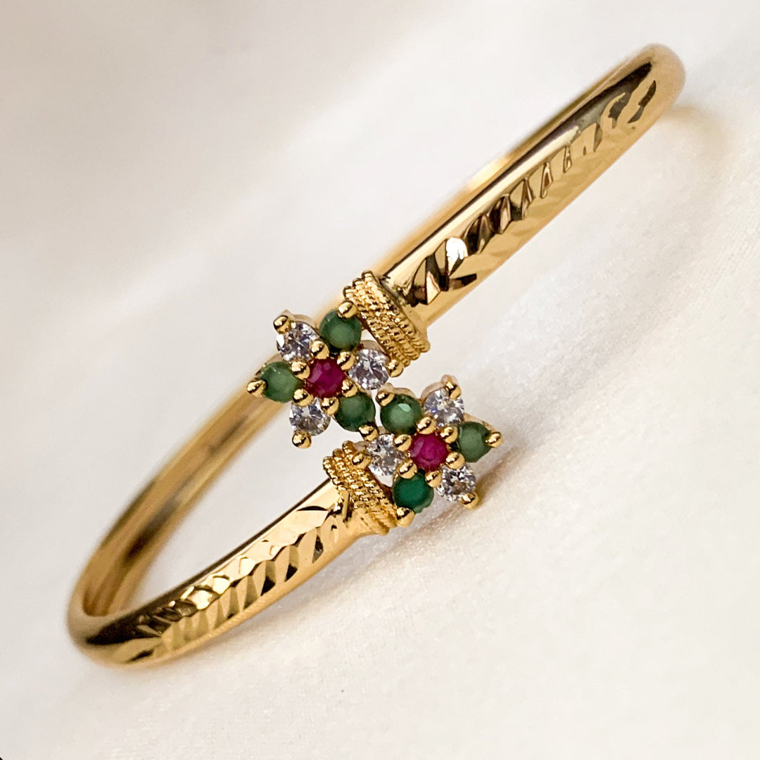 Gold bracelet with gemstones on a light background