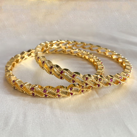 Gold-plated traditional bangles adorned with ruby-colored stones – classic Indian jewelry for women