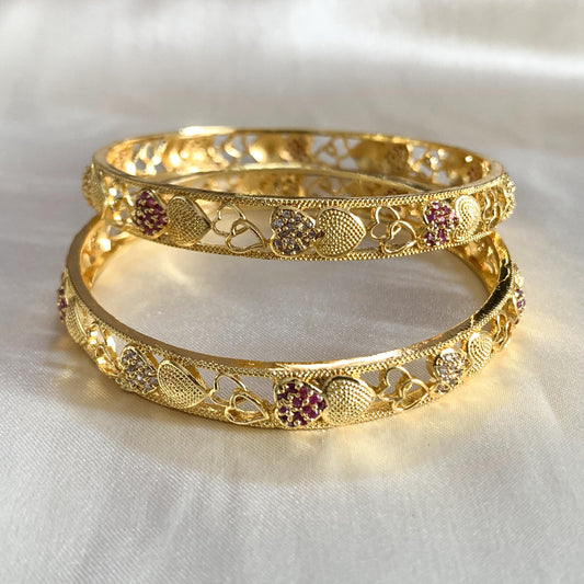 Stylish gold-plated bangles with delicate heart shapes and red and clear stone embellishments – ideal for gifting or special occasions