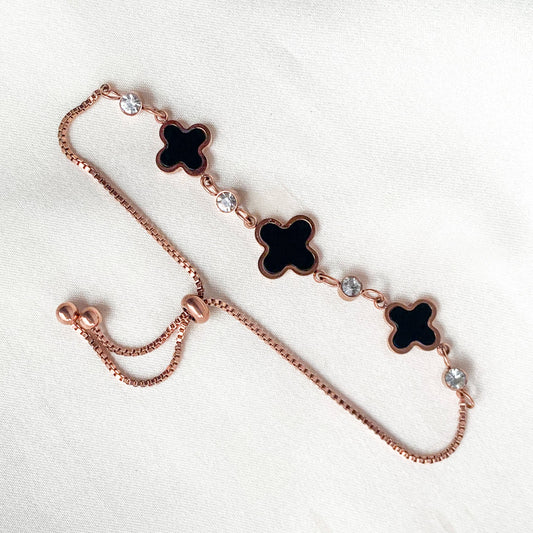 Stylish rose gold bracelet featuring black enamel clover charms and sparkling crystals – chic accessory for modern fashion