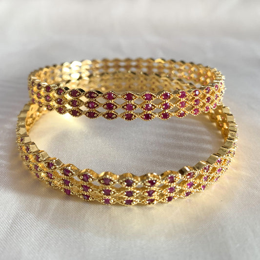 Traditional gold-toned lattice design bangles adorned with pink stones – perfect for festive and cultural wear