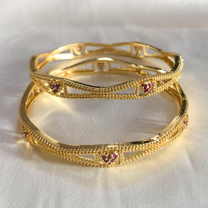 Charming gold-plated bangles with heart-shaped pink accents – feminine and stylish accessory for cultural events