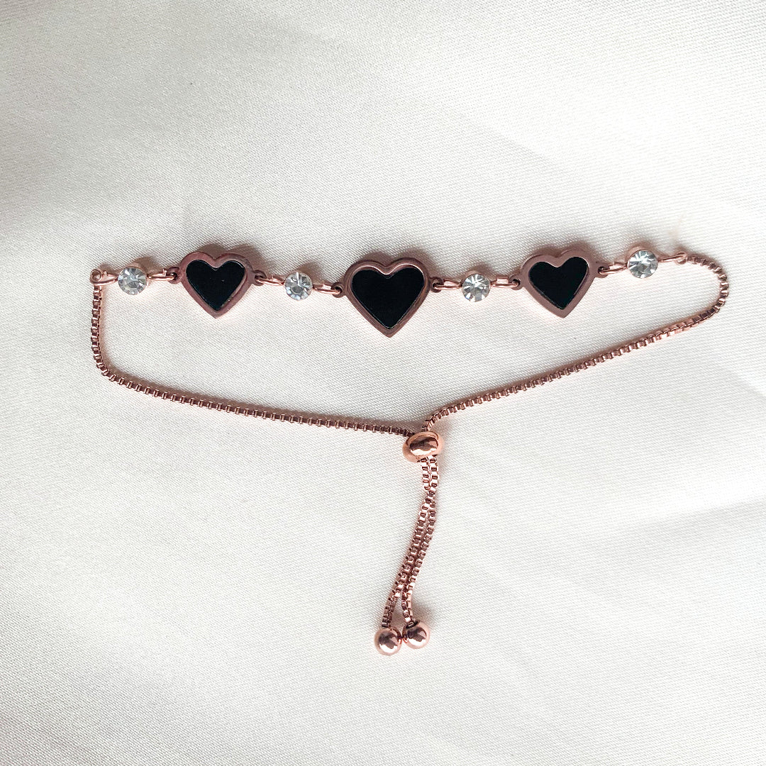 Delicate rose gold bracelet with adjustable fit, black enamel hearts, and crystal embellishments – stylish accessory for casual or festive looks