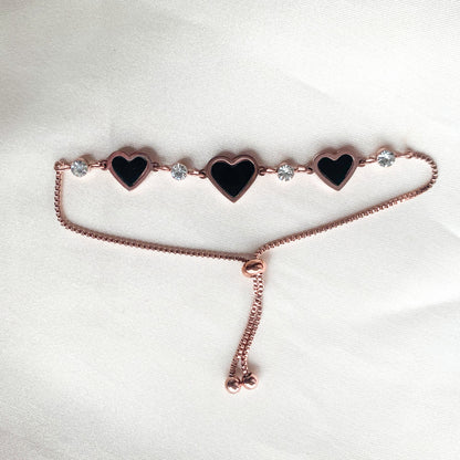 Delicate rose gold bracelet with adjustable fit, black enamel hearts, and crystal embellishments – stylish accessory for casual or festive looks
