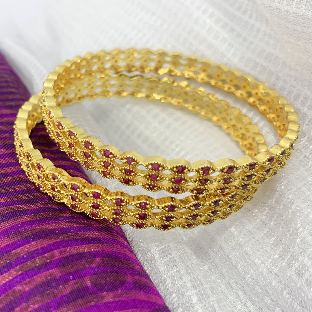 Elegant ethnic bangles featuring intricate gold lattice work and delicate pink stones – ideal for weddings and special occasions