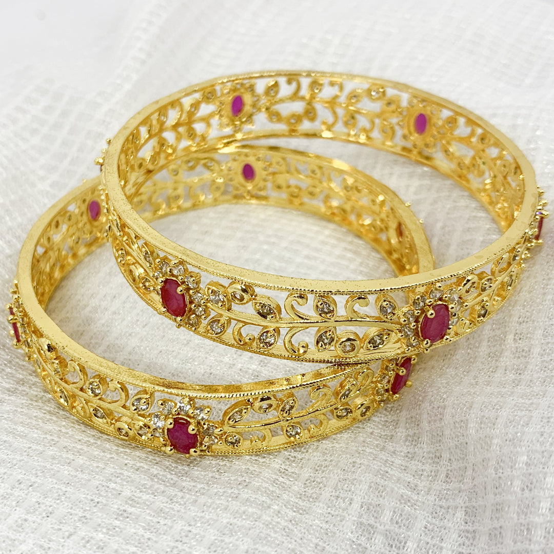 Elegant ethnic gold-plated bangles with pink accents and CZ work – traditional jewelry for special occasions