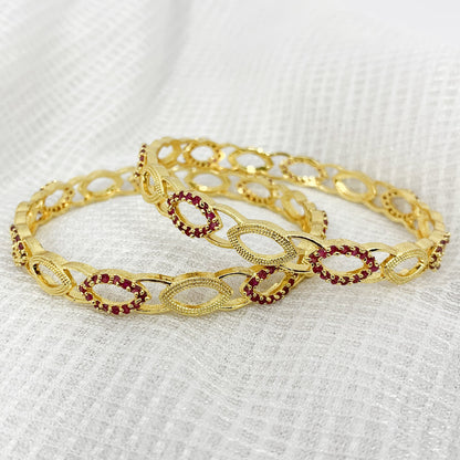Elegant gold-plated bangles with sparkling pink crystal detailing – stylish accessory for traditional occasions