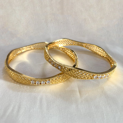 Elegant gold bangles with white stone detailing – stylish and sophisticated ethnic jewelry for weddings and parties