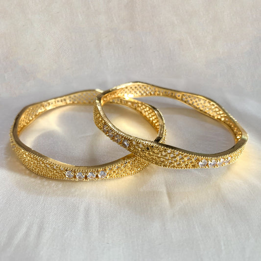 Elegant gold bangles with white stone detailing – stylish and sophisticated ethnic jewelry for weddings and parties