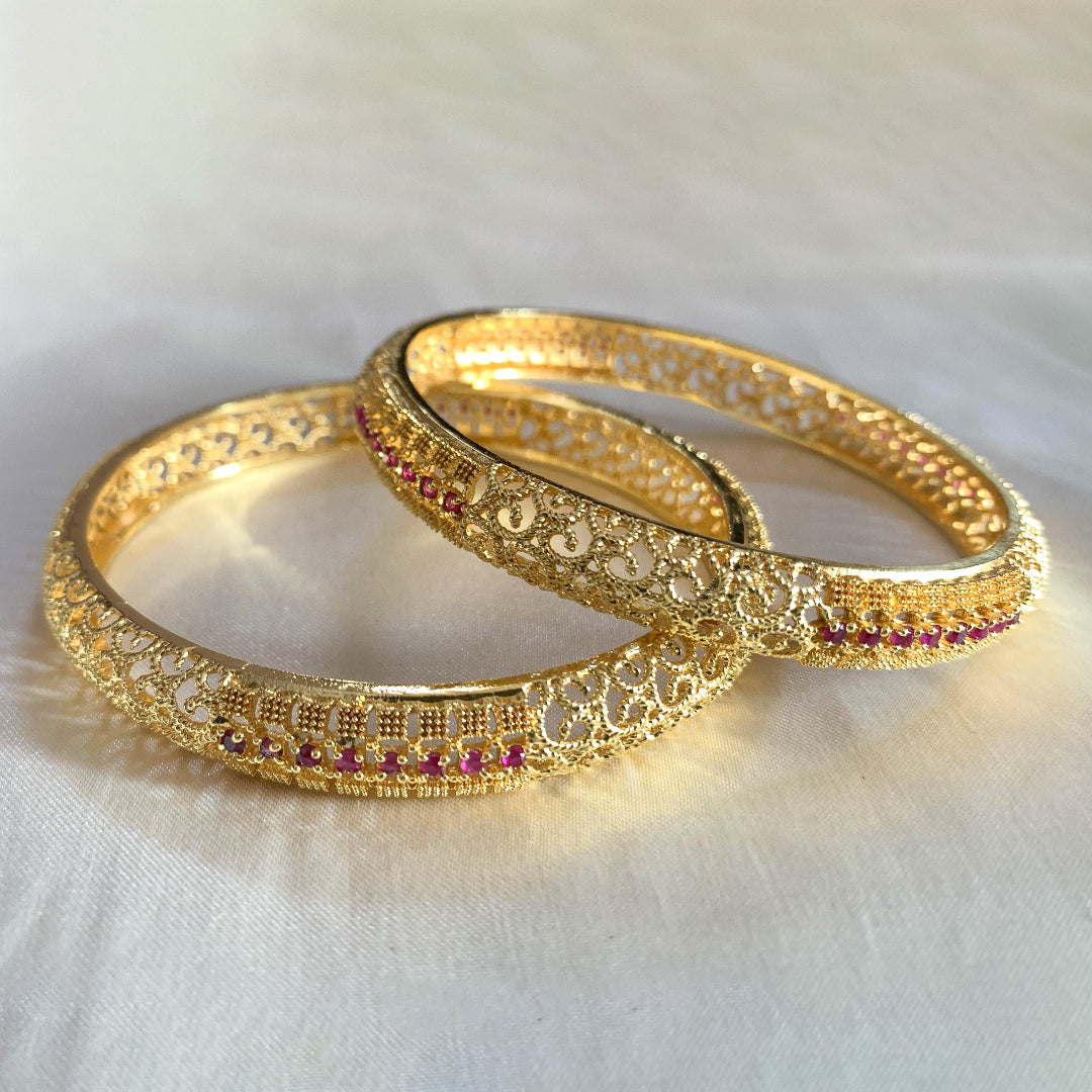 Elegant gold filigree bangles with pink stone highlights – traditional charm for festive and bridal occasions