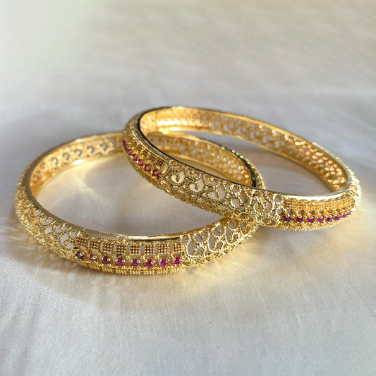 Elegant gold filigree bangles with pink stone highlights – traditional charm for festive and bridal occasions