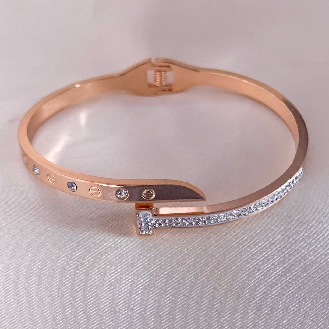 Elegant rose gold bangle featuring a modern nail-inspired design with crystal embellishments – trendy accessory for parties or gifting