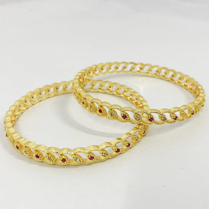 Gold-plated bangles with loop design and pink stone accents – traditional Indian jewelry for festive and bridal wear