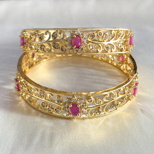 Gold-plated bridal bangles featuring bold pink stones and shimmering cubic zirconia – perfect for weddings and festivals