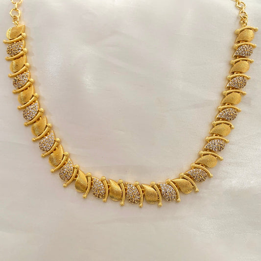 Gold-plated leaf design necklace featuring sparkling diamond-cut stones – perfect for festive and formal occasions