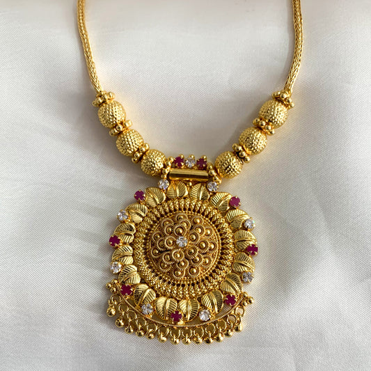 Intricately designed gold-plated necklace with ruby accents – timeless Indian jewelry for women’s cultural celebrations
